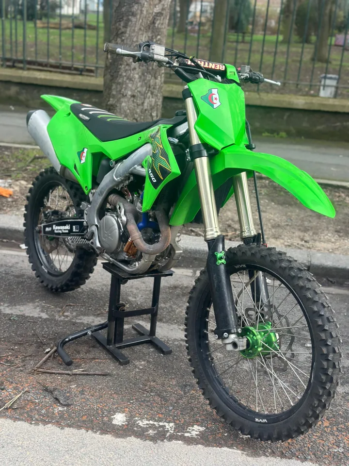 Moto de cross verte présentée sur un lève-moto.